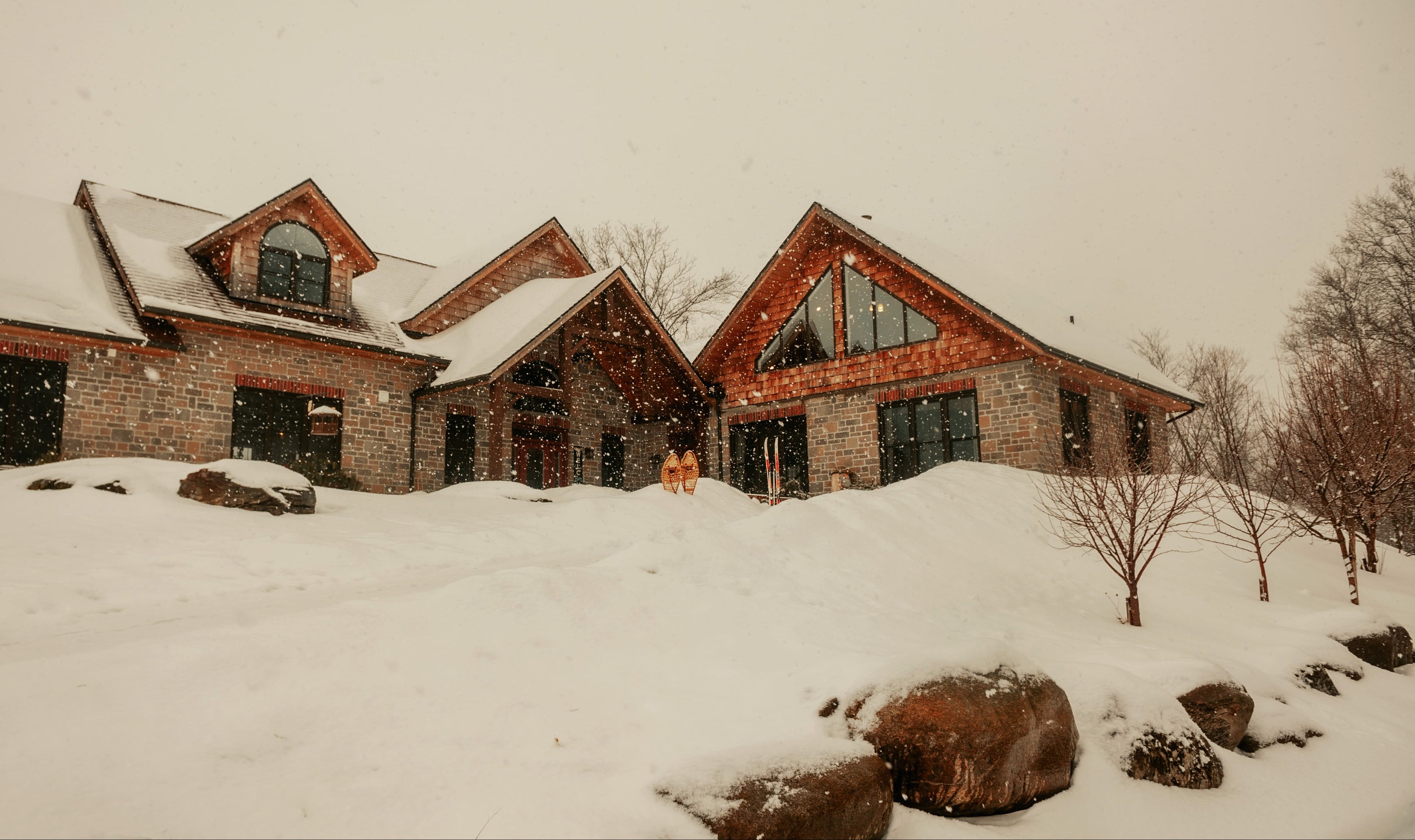 Wooden cabin in a snowy landscape with trees in the background